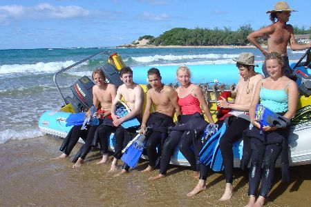 divers sitting on a boat on the beach ready for a dive