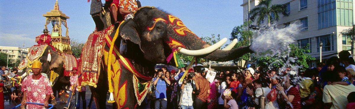 Songkran elephant blowing water from its trunk in parade