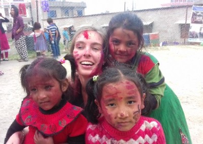Volunteer with 3 young girls Holi festival India