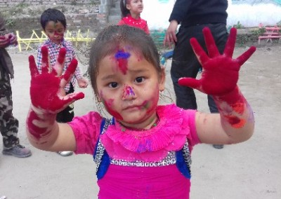 Young girl with red hands Holi festival India