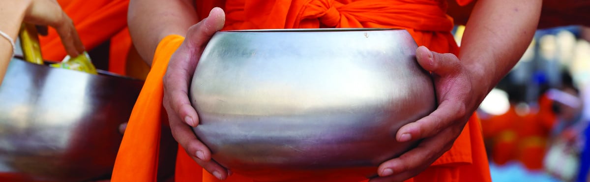 monk with prayer bowl in thailand