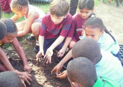 Children planting seeds spring break farming Belize