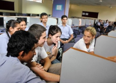 group of teens surrounding a computer learning