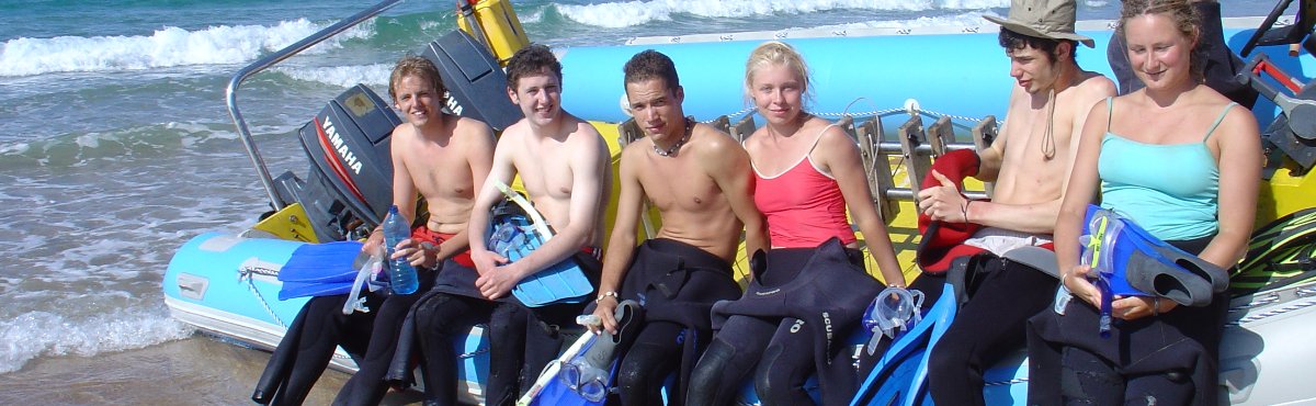 divers sitting on a boat on the beach ready for a dive