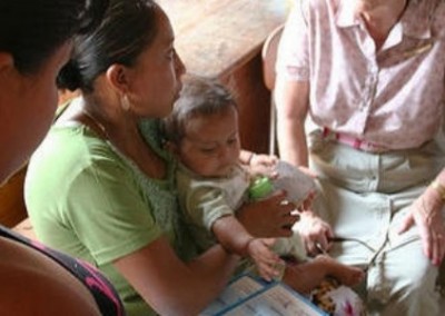 Lady holding baby social work Belize