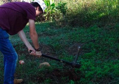 building project volunteer in Swaziland with a pick axe