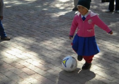 Little girl playing football sports coaching and community work Bolivia