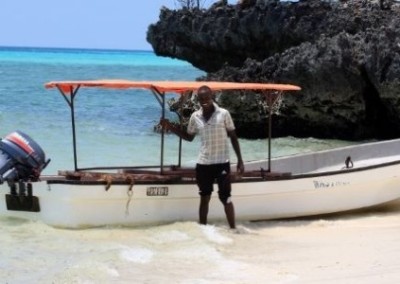 Man stood next to boat Dolphin and Marine Conservation in Zanzibar