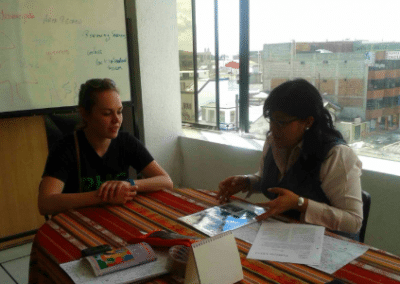 Volunteer and teacher at a table at teacher training centre in Ecuador