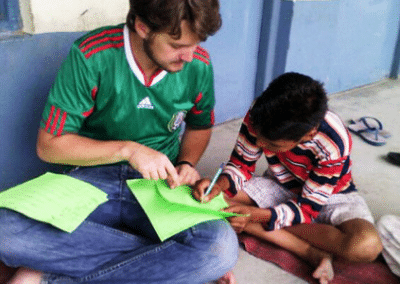 Volunteer and boy reading Child Development Volunteering in India