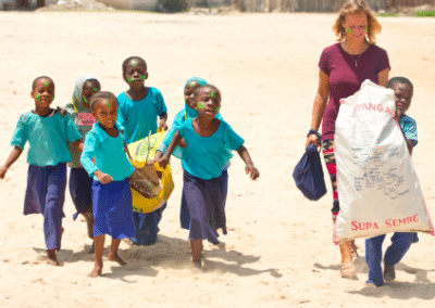 Volunteer with kids on beach Dolphin and Marine Conservation in Zanzibar