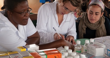Female medical intern working with staff in a hospital