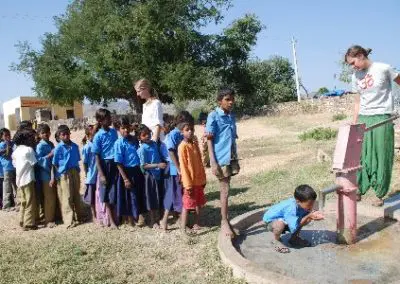 children-drinking-from-well-india