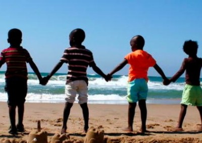 Children holding hands on the beach community sports coaching South Africa