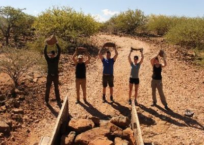 Group holding rocks above heads Elephant and Water Access project Namibia