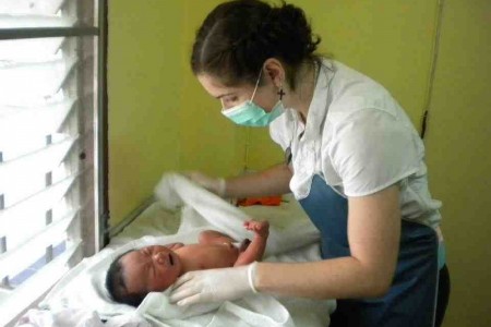 medical volunteer on a project with a baby