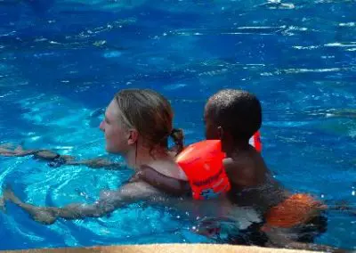 Volunteer abroad in Swaziland sports male volunteer swimming with child