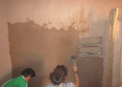 Volunteers plastering healthy kitchens Peru