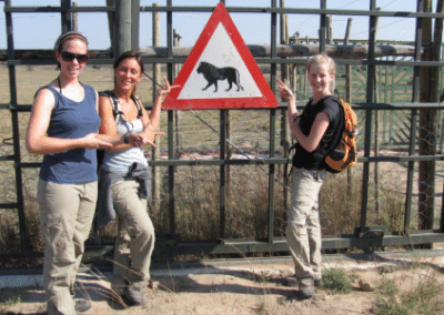 volunteers posing next to a lion road sign