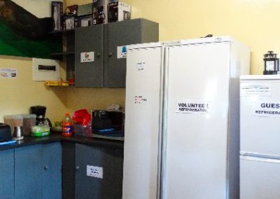 A kitchen with a refrigerator, microwave, and coffee maker.