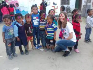 Volunteer with group of children Holi festival India
