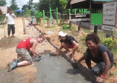3 volunteers using cement to create roads in rural cambodia