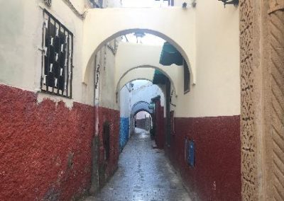 A narrow alley featuring red and white walls.