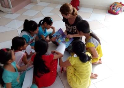 A volunteer reading a book to the children in Vietnam.