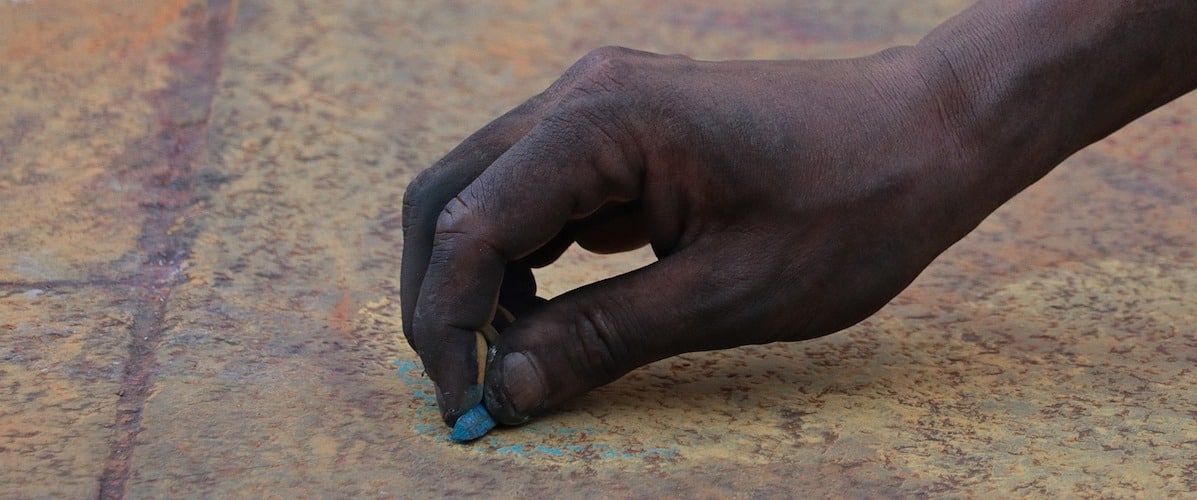street painting belize man drawing on ground with chalk