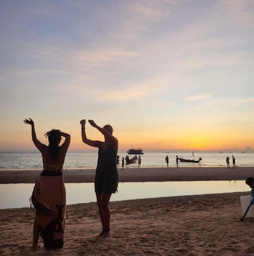 two interns dancing at sunset on the beach