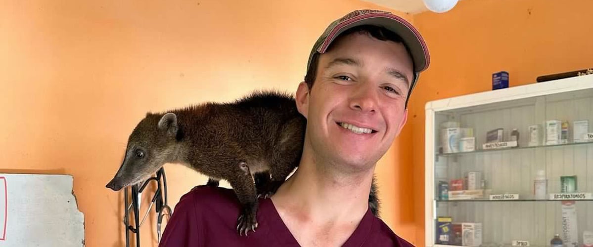 Connor White Ecuador 2 veterinary intern in Ecuador with animal on shoulder