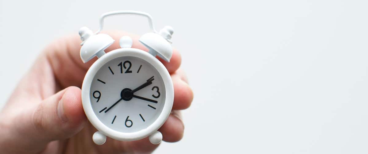 lukas-blazek-UAvYasdkzq8-unsplash hand holding a small white clock