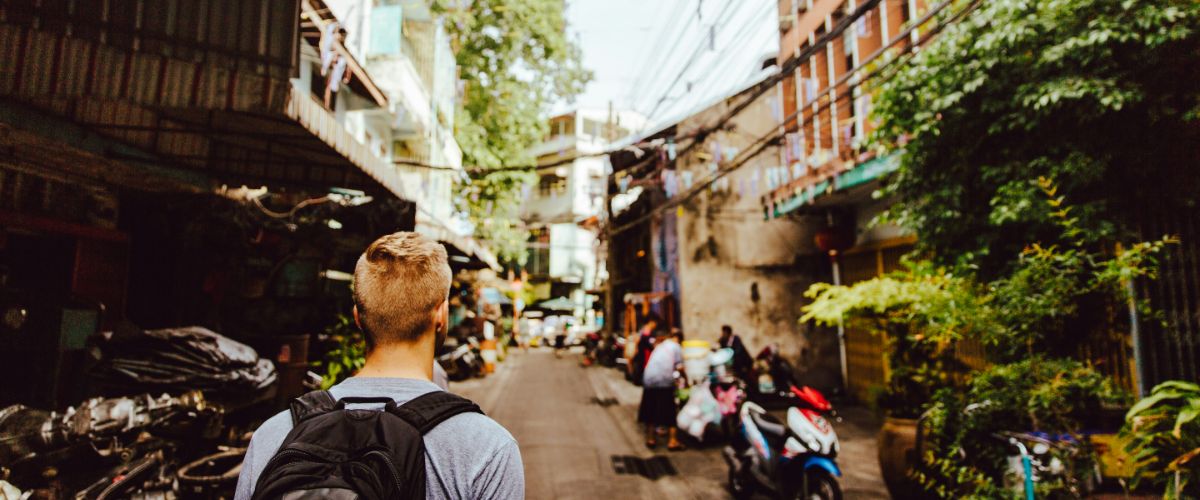 Traveler walking through a narrow, busy street